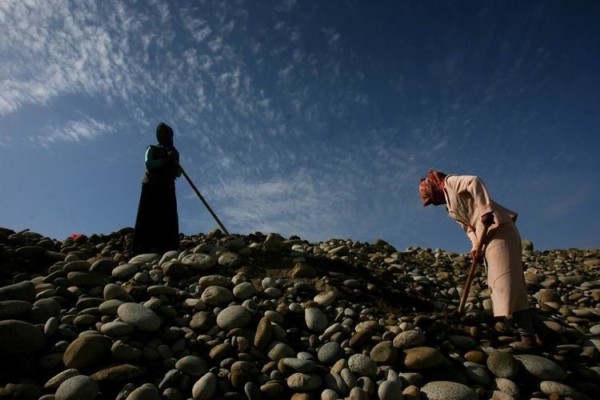 在和田市郊的玉龍喀什河的干枯河道上，連當(dāng)?shù)氐膵D女也參與玉石狂潮中。